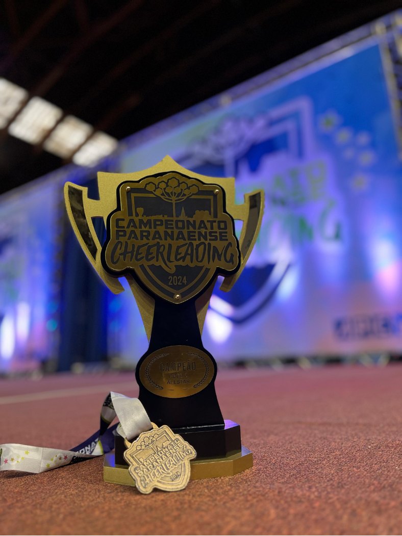 Troféu de campeão do Campeonato Paranaense de Cheerleading 2024, ao lado da medalha